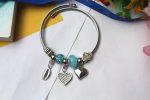 Silver-Toned Ocean-Inspired Charm Bangle Bracelet with Blue Murano Bead, Heart, Feather & Cowrie Shell Dangles - Image 2
